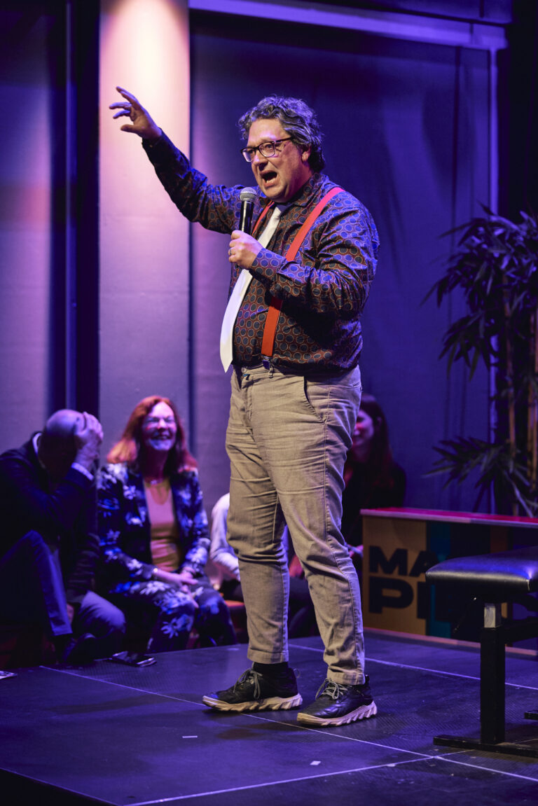 Man die enthousiast praat in zijn microfoon.