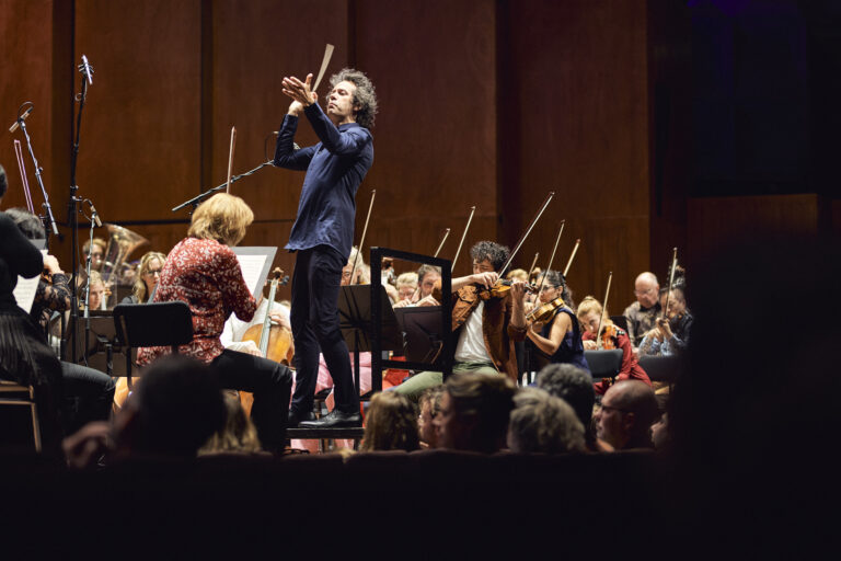 Orkest met op een verhoging de dirigent.
