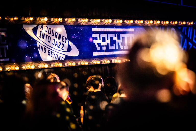 Een sfeervolle afbeelding van een podium met een opvallend verlichte banner die