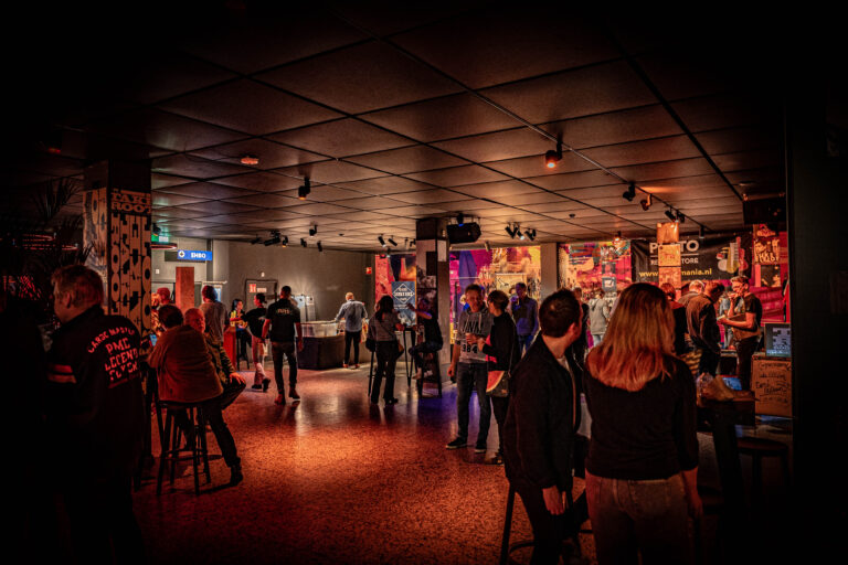 Een drukke bar met mensen die socialiseren en genieten van de sfeer onder gedimd licht.