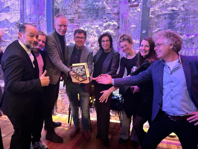 Collega's van SPOT Groningen laten trots de Popgala Noord Award voor Beste podium zien