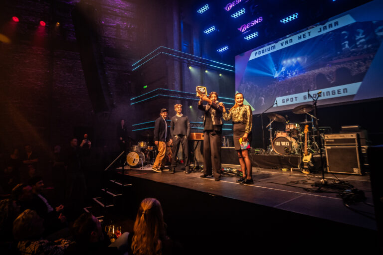 Directeur Nynke Stellingsma neemt de award voor beste podium in ontvangst op het podium van Popgala Noord