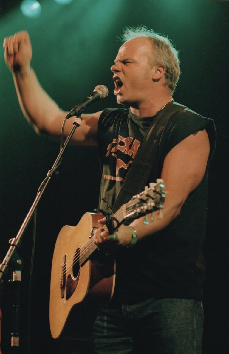 Man die aan het zingen is is met een gitaar