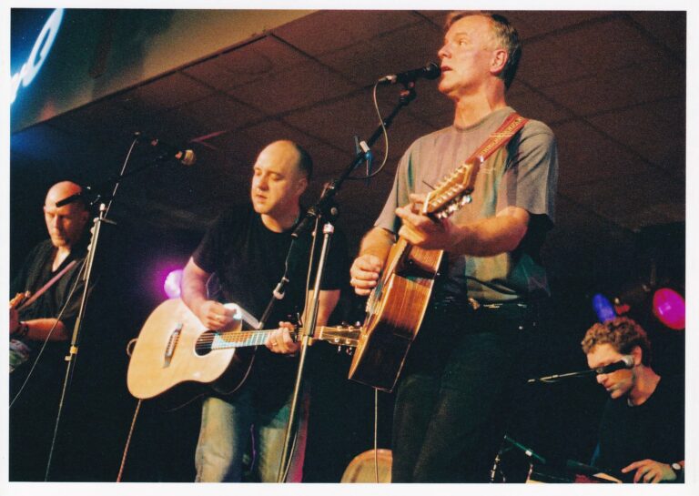 Twee mannen met een gitaar en microfoons