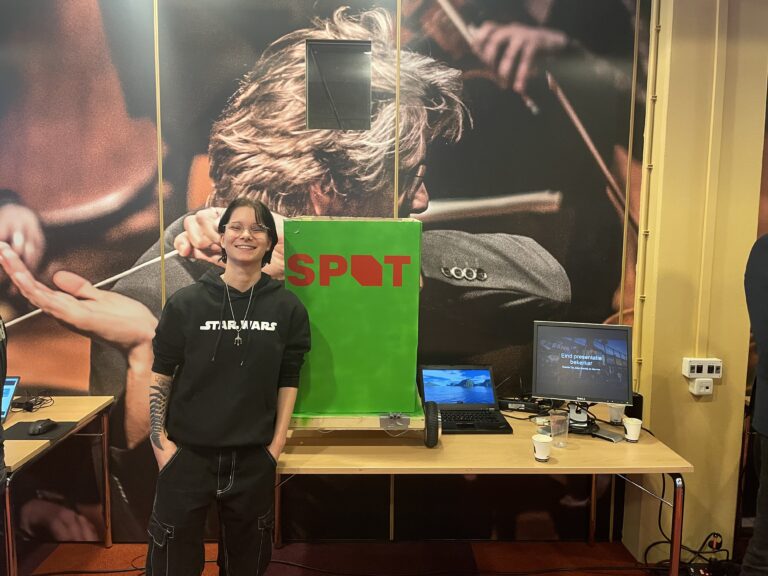 Een persoon staat naast een groen bord met de tekst