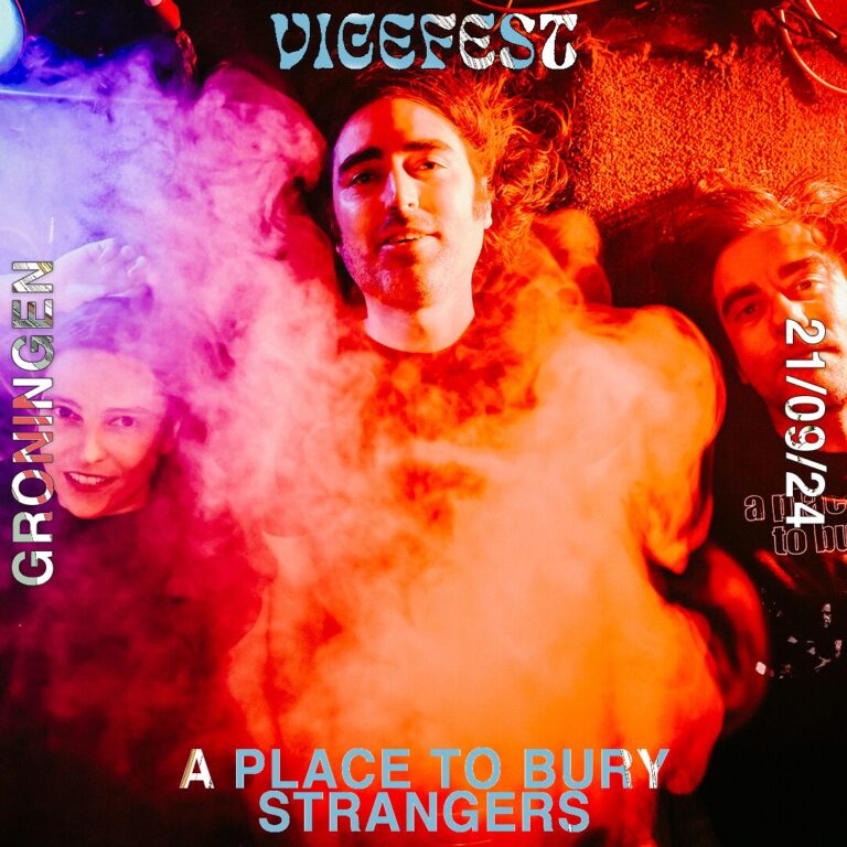 Drie bandleden staan in gekleurde rook in de kleuren paars, oranje en rood.