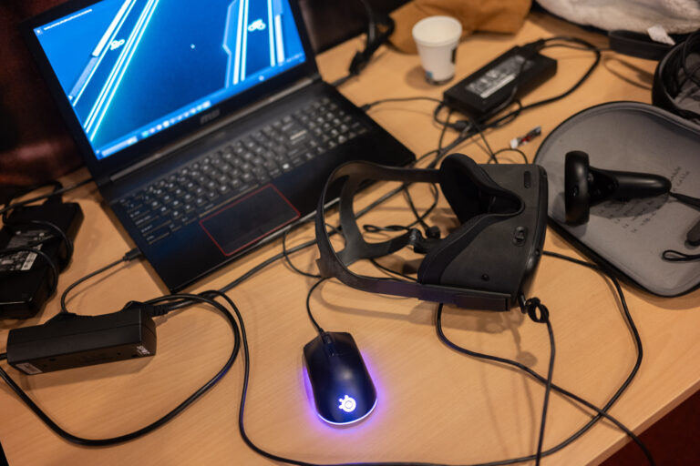 Foto van opgeklapte laptop en kabels van boven.