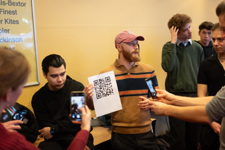 Studenten scannen met telefoon QR-code van a4-tje