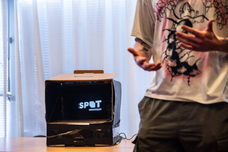 Doos met scherm uitvergroot met persoon rechts.