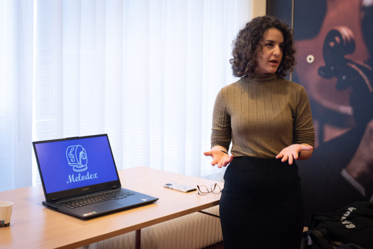 Vrouw met donker haar en krullen presenteert