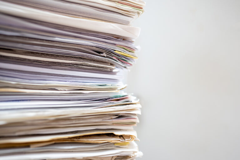 Stapel papieren en onderzoeken met een witte achtergrond.