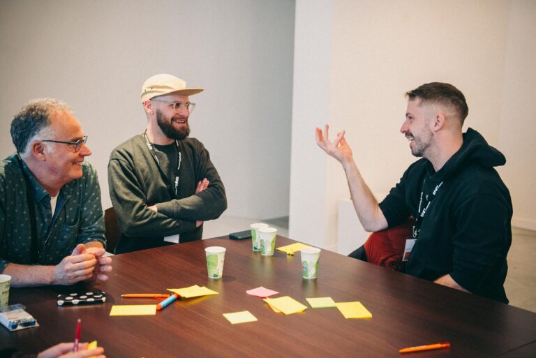 drie personen aan tafel in gesprek
