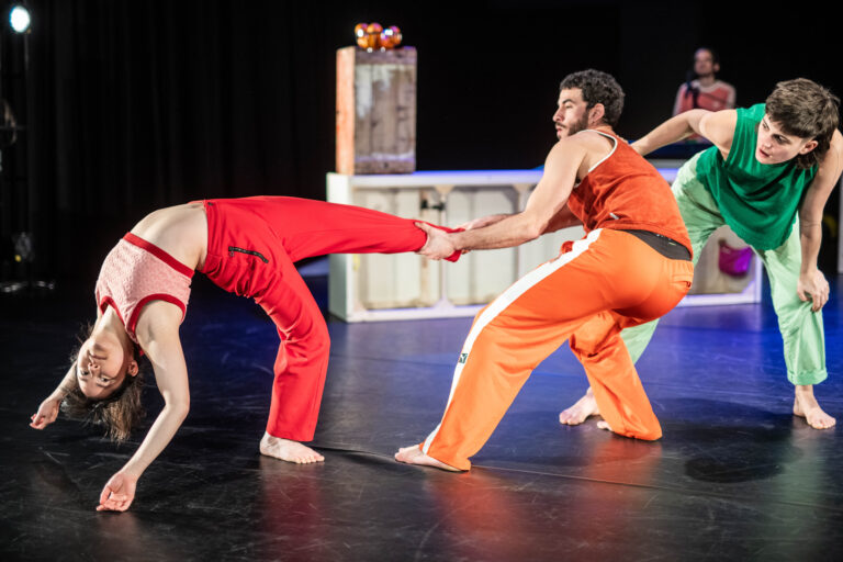 Drie dansers op het podium trekken aan elkaar