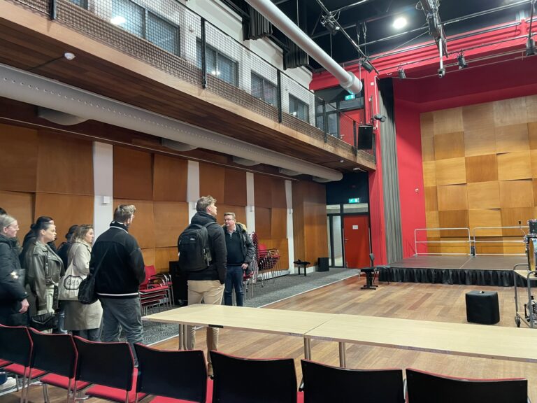mannen in een zaal met rode muur