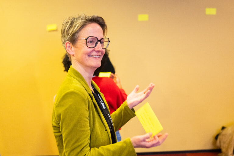 Een vrouw met een groene blouse lacht