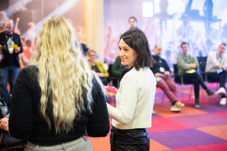 een vrouw met een witte trui kijkt naar een vrouw met een zwarte trui