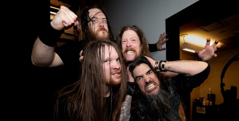 4 metalheads met lang haar trekken uitbundige gezichten voor de fotot