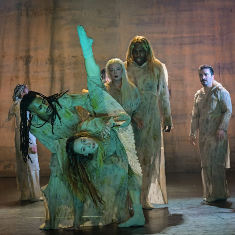 Duet van twee dansers, waarbij de vrouwelijke danser opzij leunt met één been recht omhoog