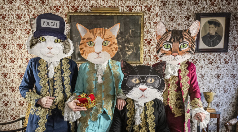 4 mannen van de groep fantastic cat in deftige kleding met poezenhoofden op