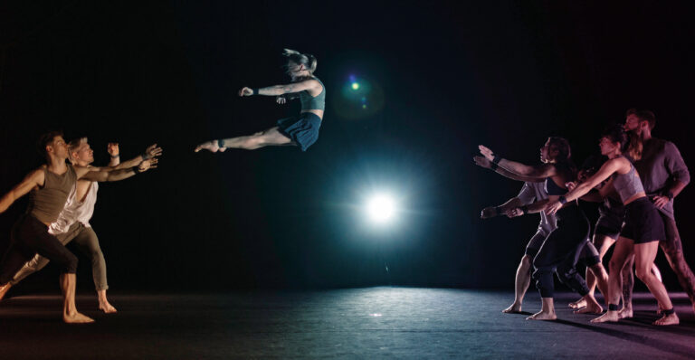 Een vrouwelijke acrobaat vliegt achterwaards door de lucht