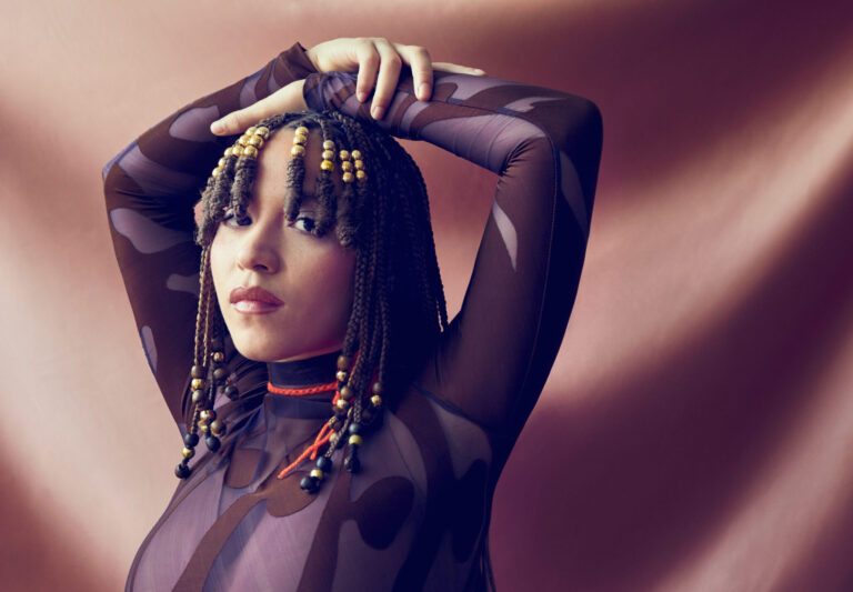 Vrouw met bruine top heeft armen boven haar hoofd