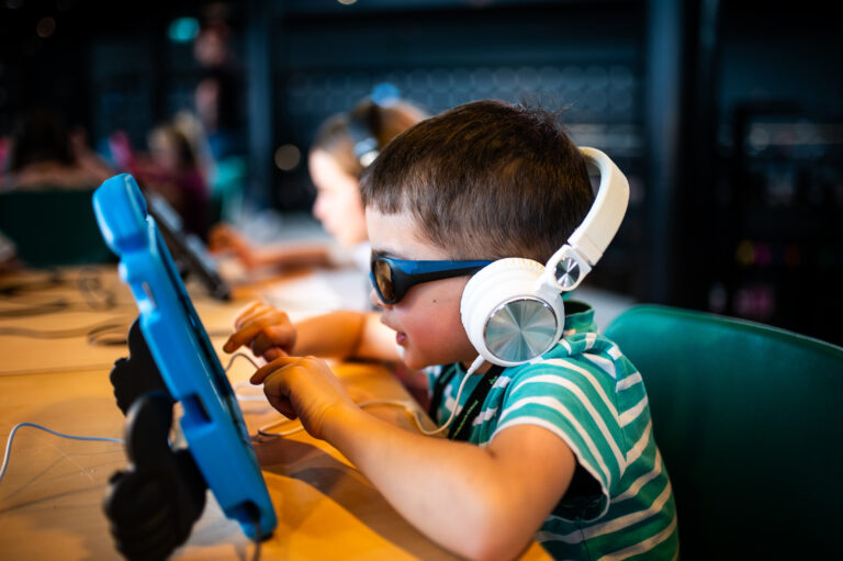Jongen met koptelefoon tijdens muziekworkshop