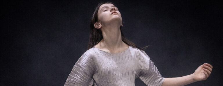 Vrouw met open armen en gezicht naar de boven gericht