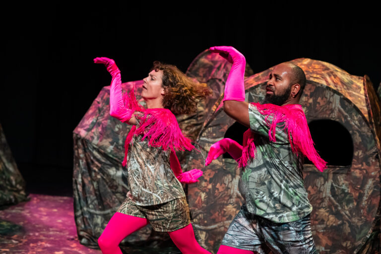 Twee acteurs staan in flamingo dans houding op een bosachtig podium