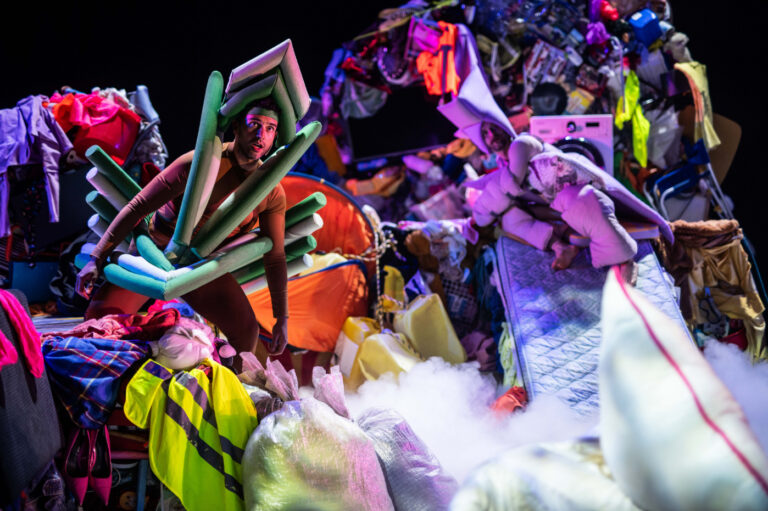 Een levendige carnavals-scene met dansende mensen in felgekleurde kostuums en kleurrijke rookwolken.