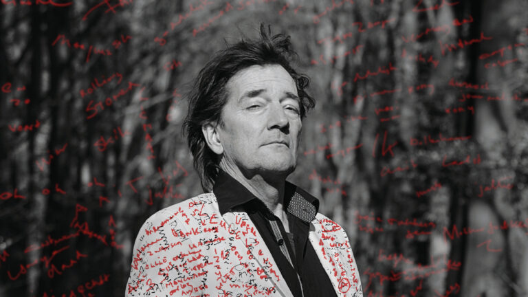 Zwart wit foto van Andre met een jasje met rode teksten en teksten in de lucht