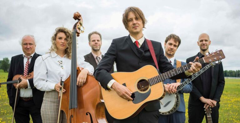 Bertolf staat met band in een weiland