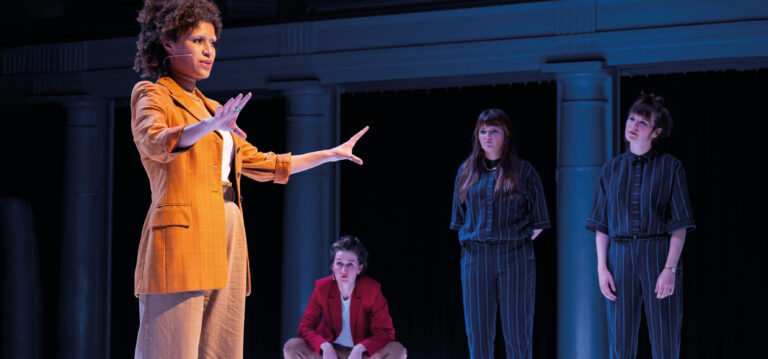 Actrice spreekt terwijl een aantal acteurs toekijken