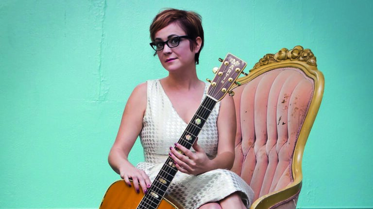 carter sampson met rode laarzen op stoel voor blauwe muur