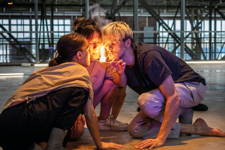 Drie mensen met een brandende lucifer in hun mond brengen deze naar een vierde lucifer