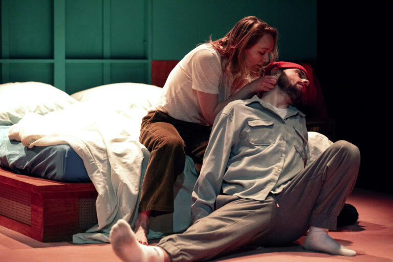 Twee mensen op een bed terwijl de ene de andere kust.