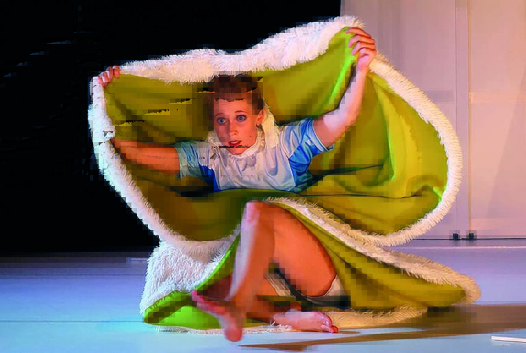 Meisje op toneel met een groene deken boven haar hoofd