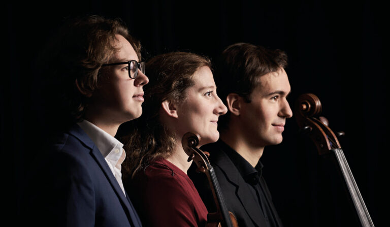 Twee mannen en vrouw met rode blouse en instrumenten