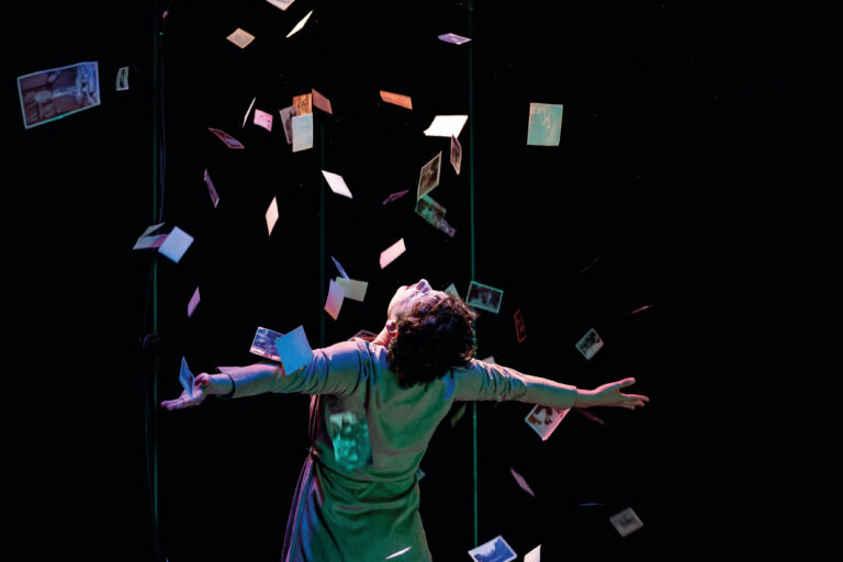 Vrouw op de rug gezien met allemaal foto's in de lucht met een donkere achtergrond