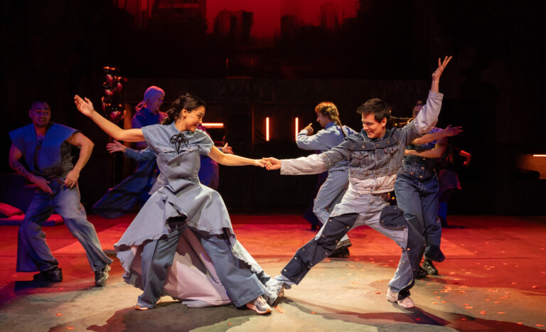 Acteur en actrice die Romeo & Julia spelen zie je samen in blauwe kleding dansen