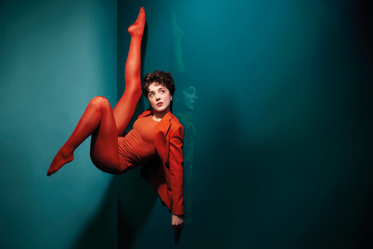 Compleet in een rood outfit ligt Selma op de rug met benen in de lucht