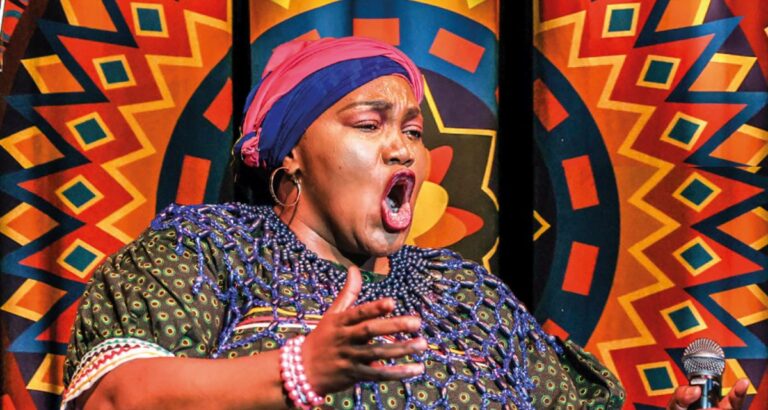 Zingende vrouw in Afrikaans traditionele kleding met het meezingende koor ervoor