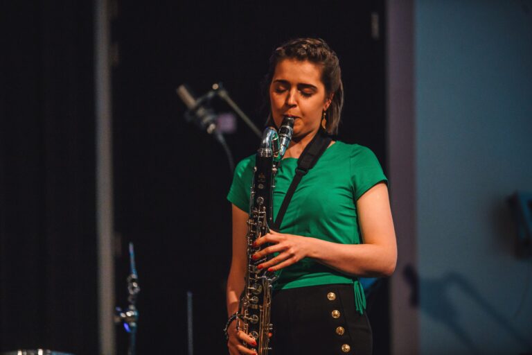vrouw met groen shirt speelt saxofoon