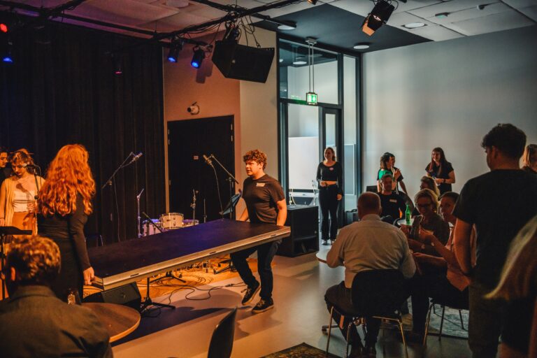 2 mensen dragen een zwarte plank