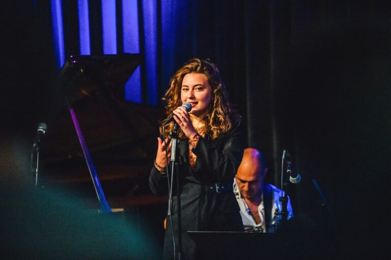 vrouw met krullend haar praat in microfoon