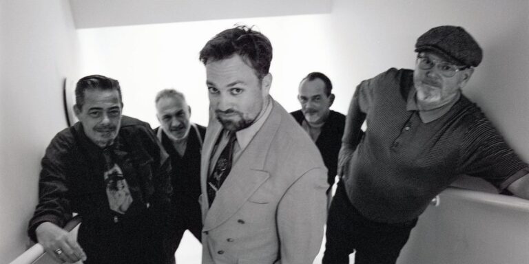 zwart wit foto van 4 mannen op een trap in pak