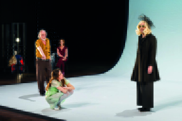 Drie acteurs kijken naar een persoon in zwarte kleding