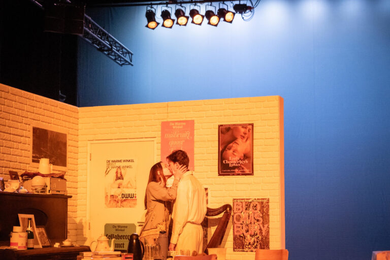 Twee acteurs geven elkaar een kus voor een kamer decor