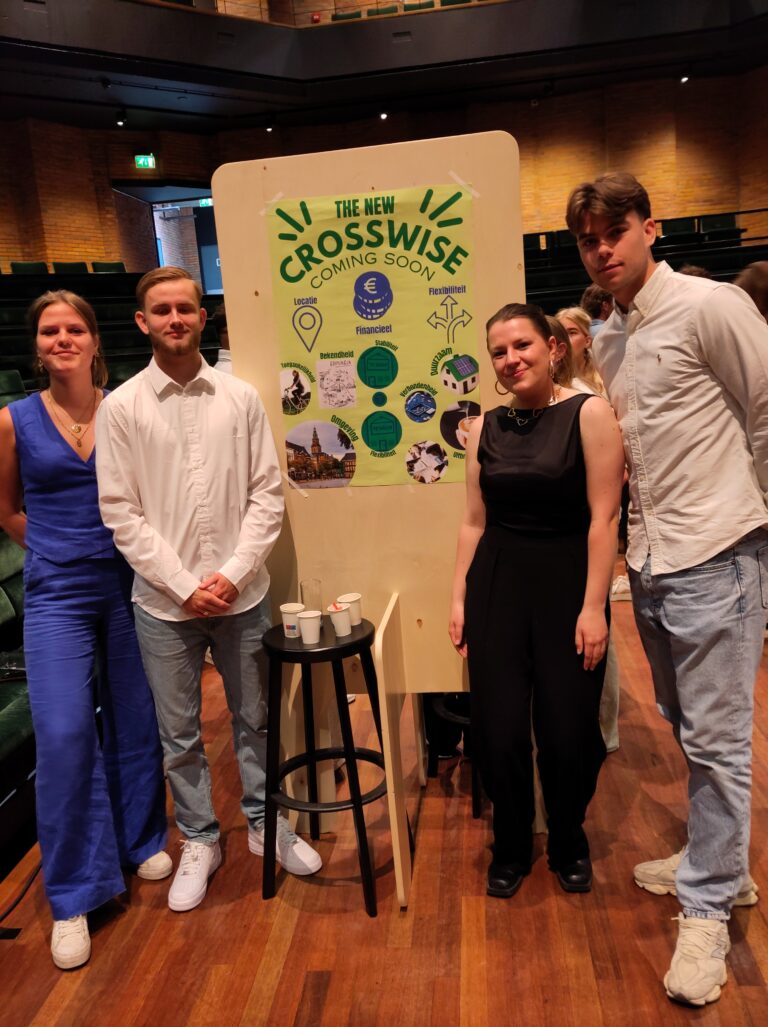 Vier mensen poseren voor een bord met het logo