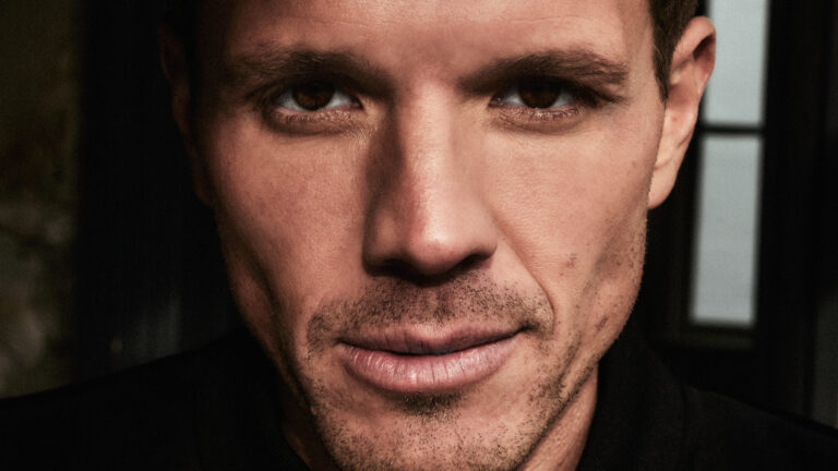 Close-up van een man met een serieuze gezichtsuitdrukking.