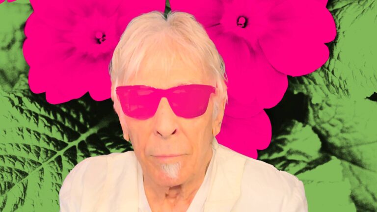 Portret van oudere man met roze zonnebril, tegen achtergrond van felgekleurde bloemen en bladeren.